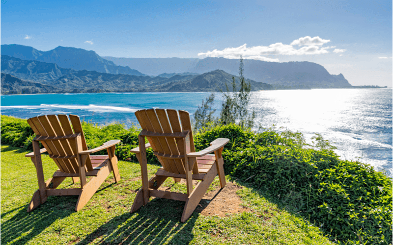 Image of two lawn chairs overlooking an ocean for a blog post on where to stay in Kauai