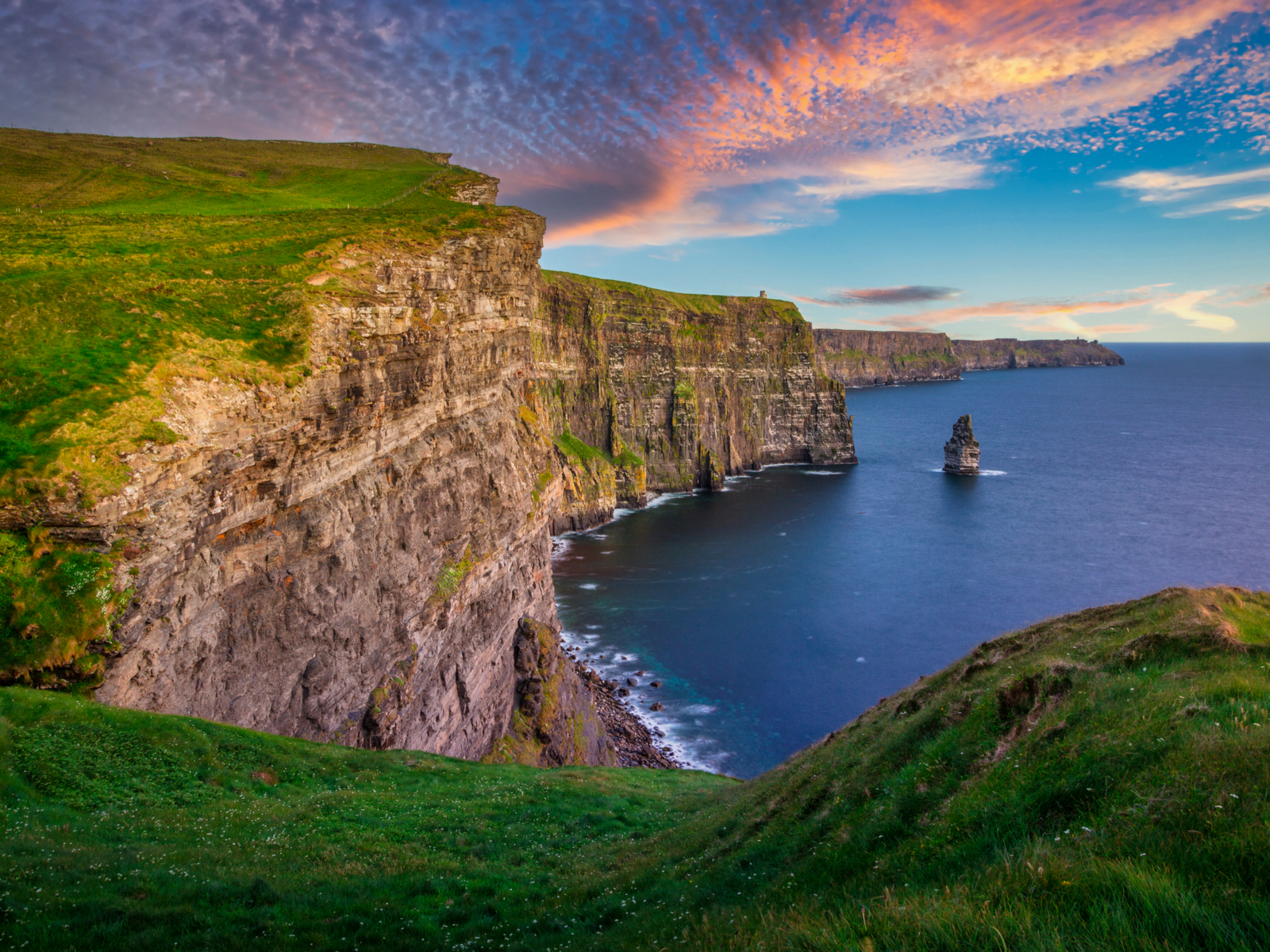 Cool view of the Cliffs of Moher (one of the best things to do in Ireland) pictured on a night with a gorgeous sunset