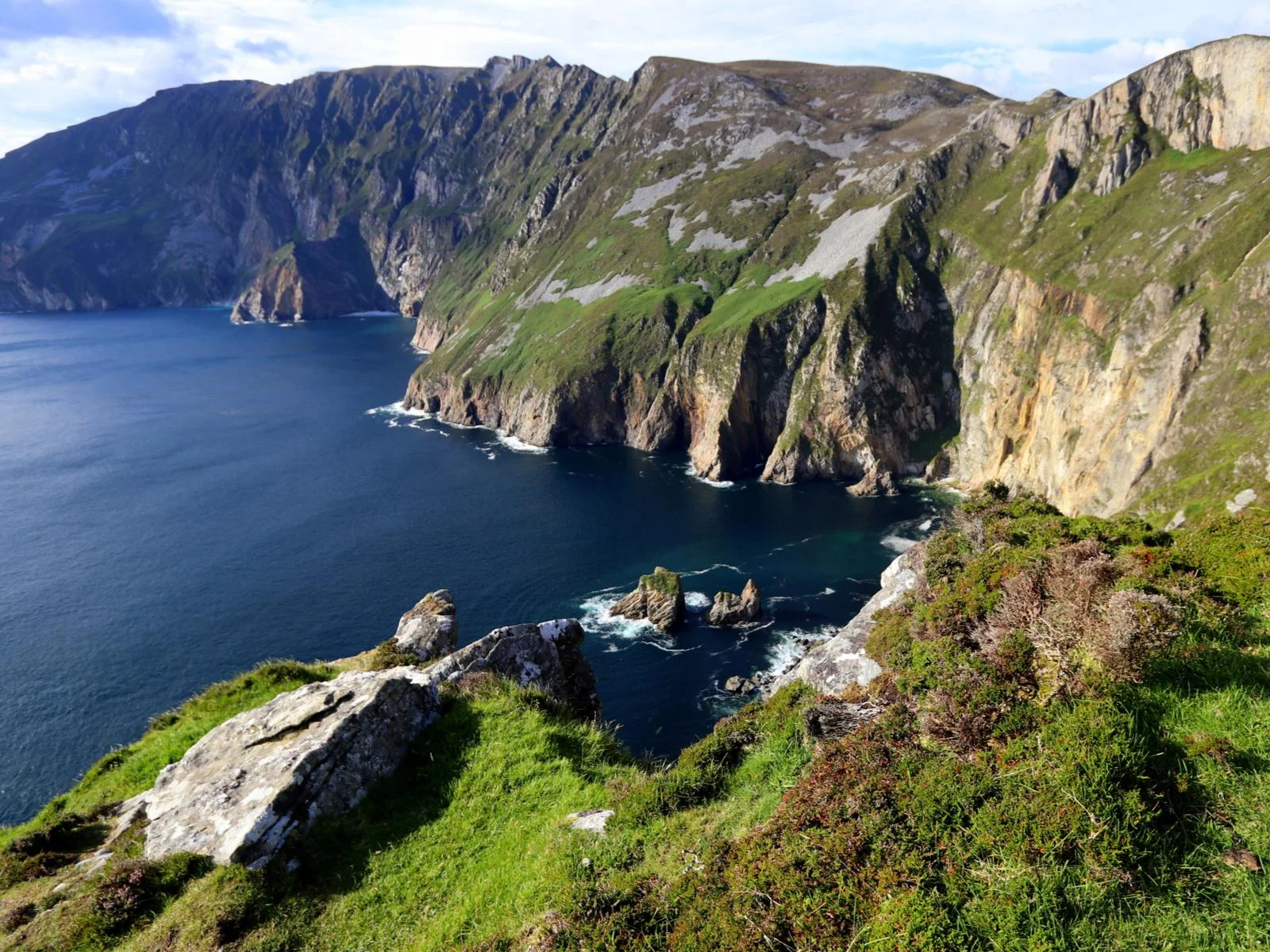 The tallest sea cliffs in Europe at Slieve League, known as one of the best places to visit in Ireland, with calm ocean at its foot
