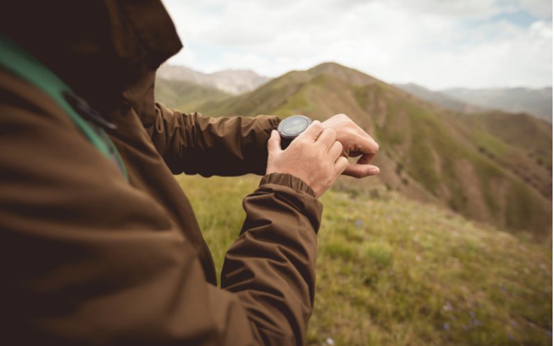 One of the best hiking watches on the wrist of a guy in a hoodie
