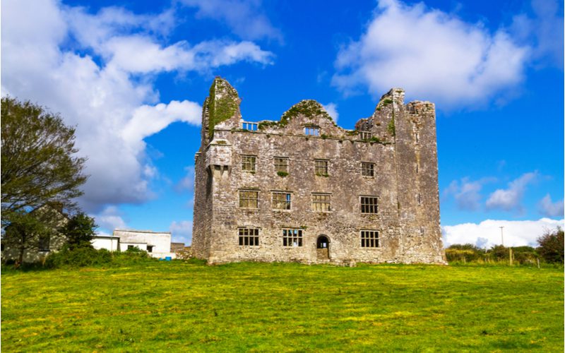 Leamaneh Castle, among the best Irish castles, as viewed on a calm day with blue skies