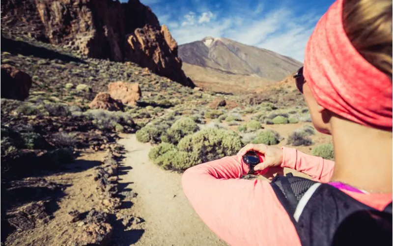 Woman wearing the best hiking watch while running a trail