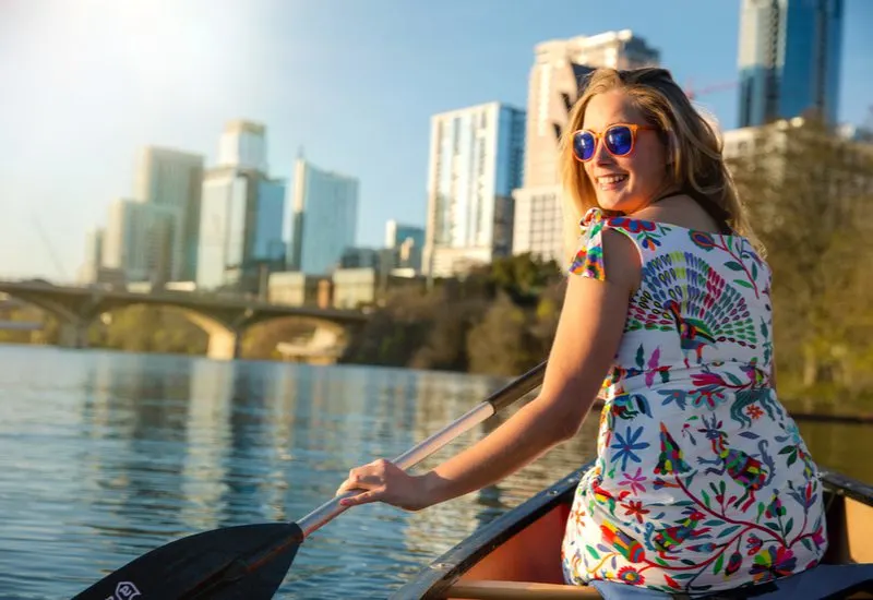 Woman kayaking on a lake in Austin for a piece on the best Airbnbs in Austin Texas