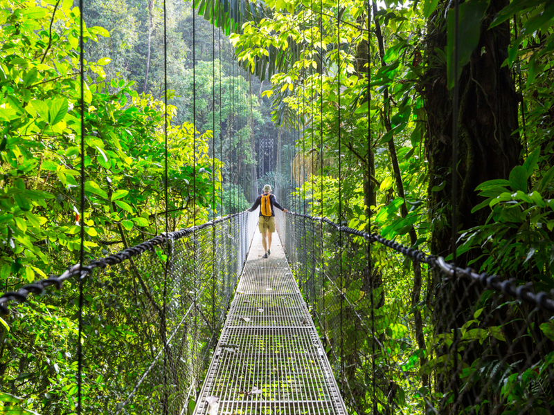 Woman on a suspension bridge during the cheapest time to go to Costa Rica
