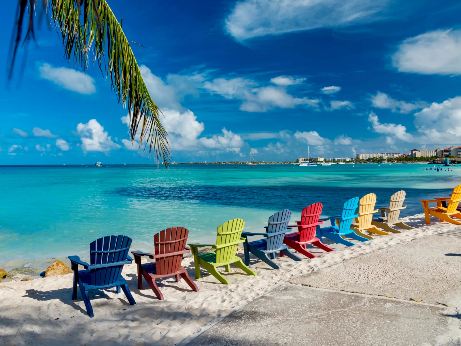 Oranjestad, Aruba pictured with colorful chairs on the beach during the least busy time to visit
