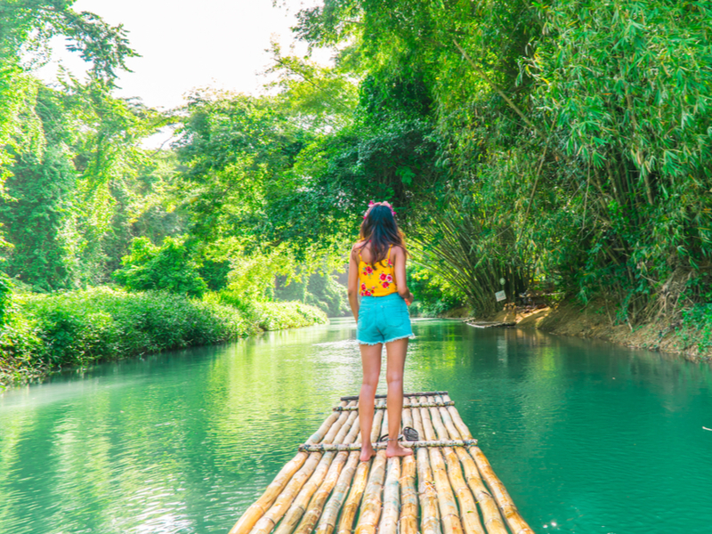 Photo of a woman standing on a raft on the Martha Brae River, one of the best places to visit in Jamaica