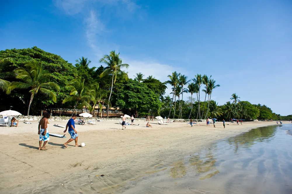 Kids playing football on the beach under a postcard-worthy sky in Guanacaste during the overall best time to visit Costa Rica