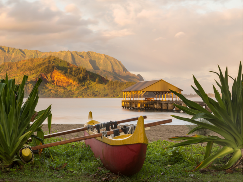 Hanalei Bay at sunrise with an outrigger canoe for a piece on the best places to visit in Hawaii