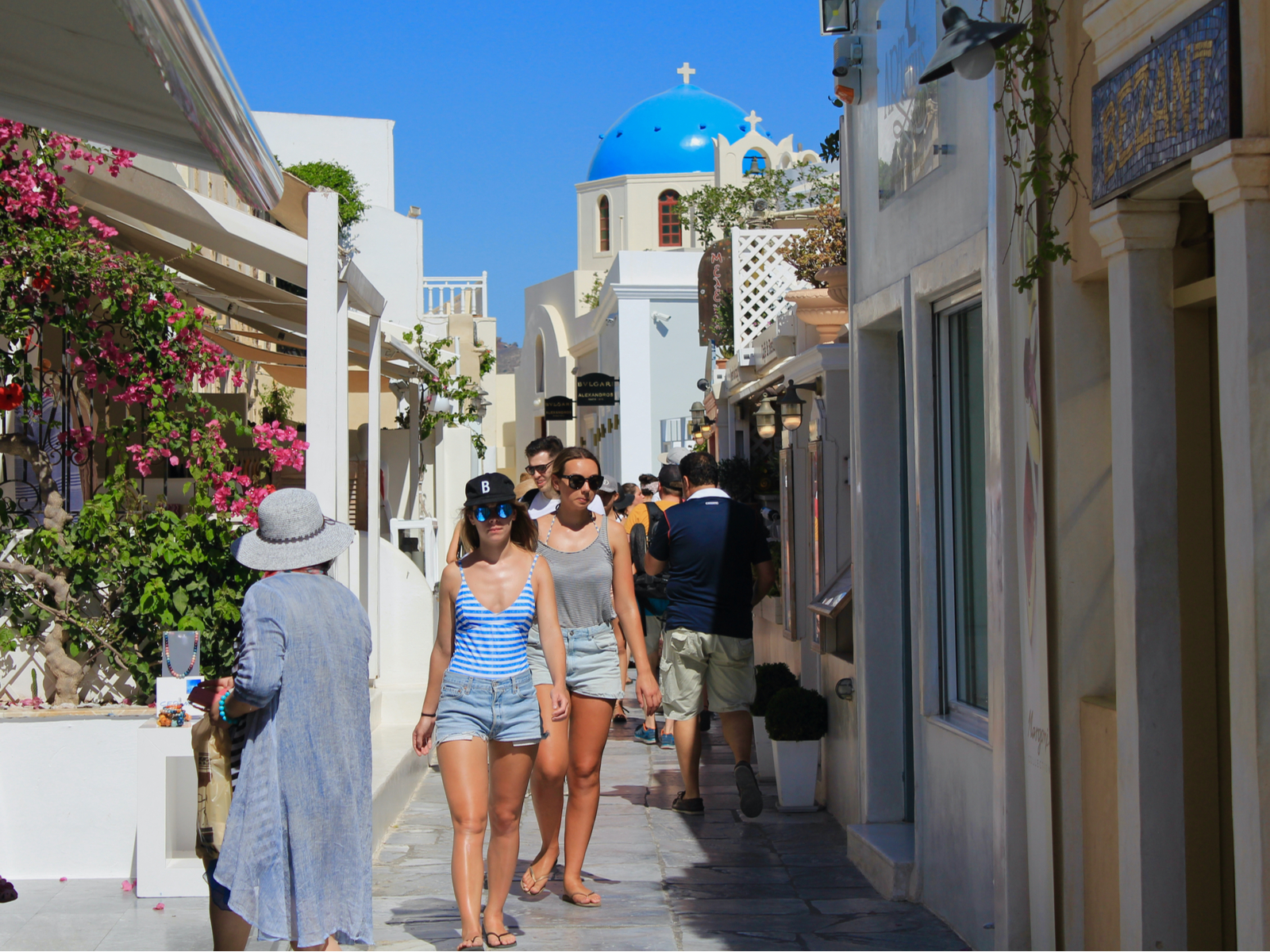 Hot young tourists in Santorini walking in the sun during summer