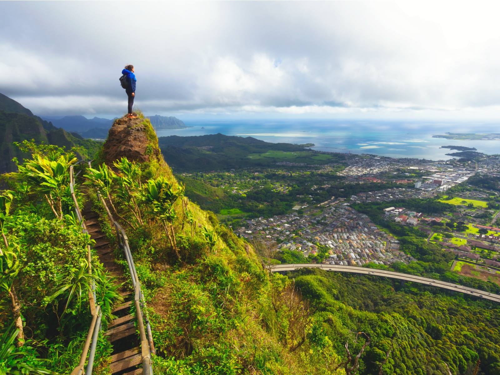 Woman standing on the tip of the best Hawaiian hike, the stairway to heaven