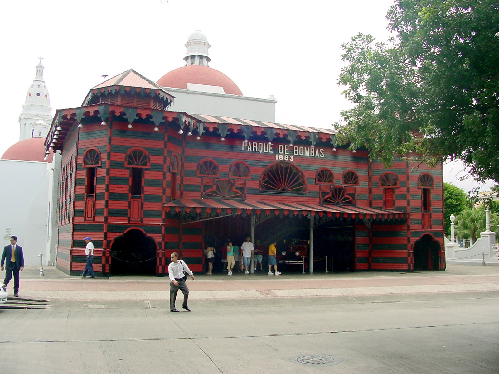 People having a tour inside the best things to do in Puerto Rico, Parque de Bombas pictured with its recognizable red and black stripes paint