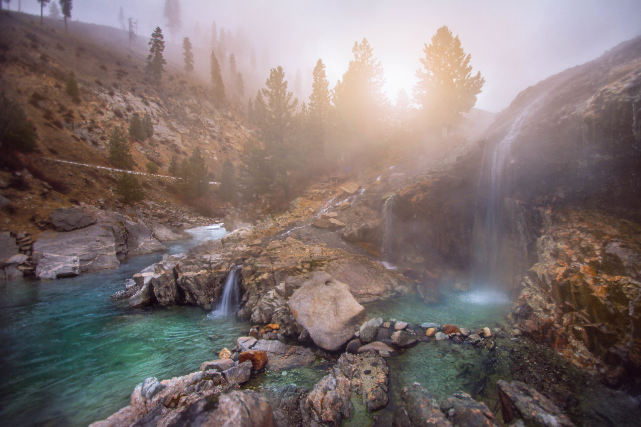Steamy Kirkham Hot Springs pictured on a bright foggy day as a piece on the best things to see in Idaho