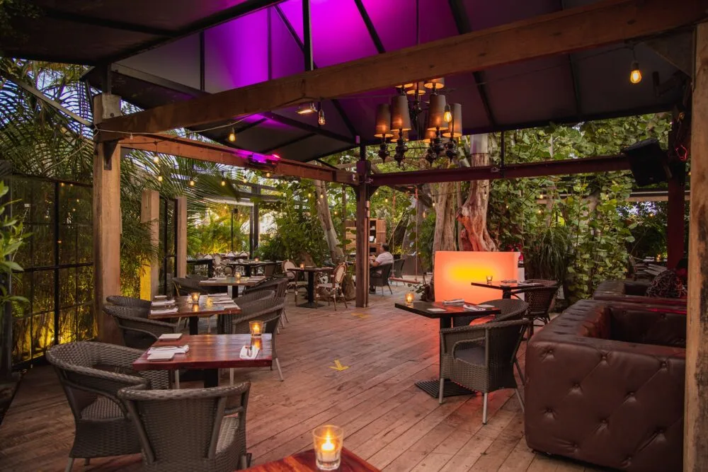 Lovely candles on each table, with a size for two, at Bohemian Bar and Restaurant's open air dining area with hardwood floor, one of the best restaurants in Aruba