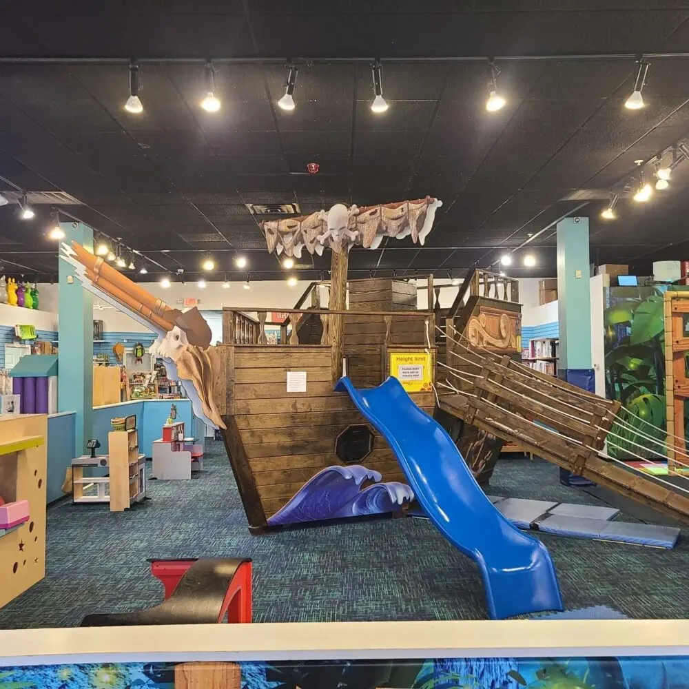 Open play area with a miniature ship and slide at one of the best toy stores in America, Smart Toys and Books in Knoxville