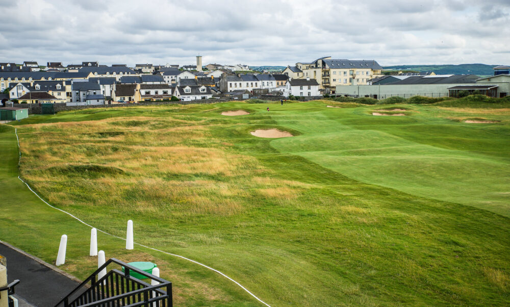 The border of populated area at Lahinch Golf Club, one of the best golf courses in Ireland, inside workers trimming the green grass
