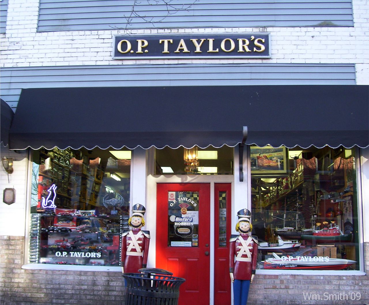 Two smiling nutcracker toys guarding the entrance of O.P. Taylor’s, one of the best toy stores in America, while the inside of the store visible through its window