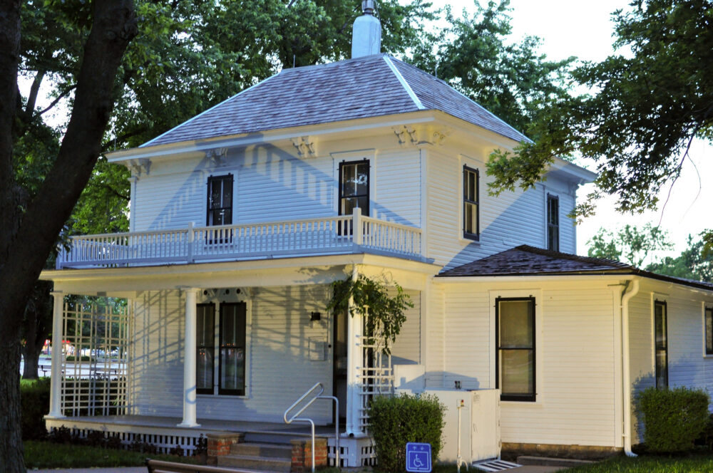 Dwight D. Eisenhower Presidential Library, Museum & Boyhood Home, one of the best things to see in Kansas, a two-storey white house with a small porch surrounded by trees