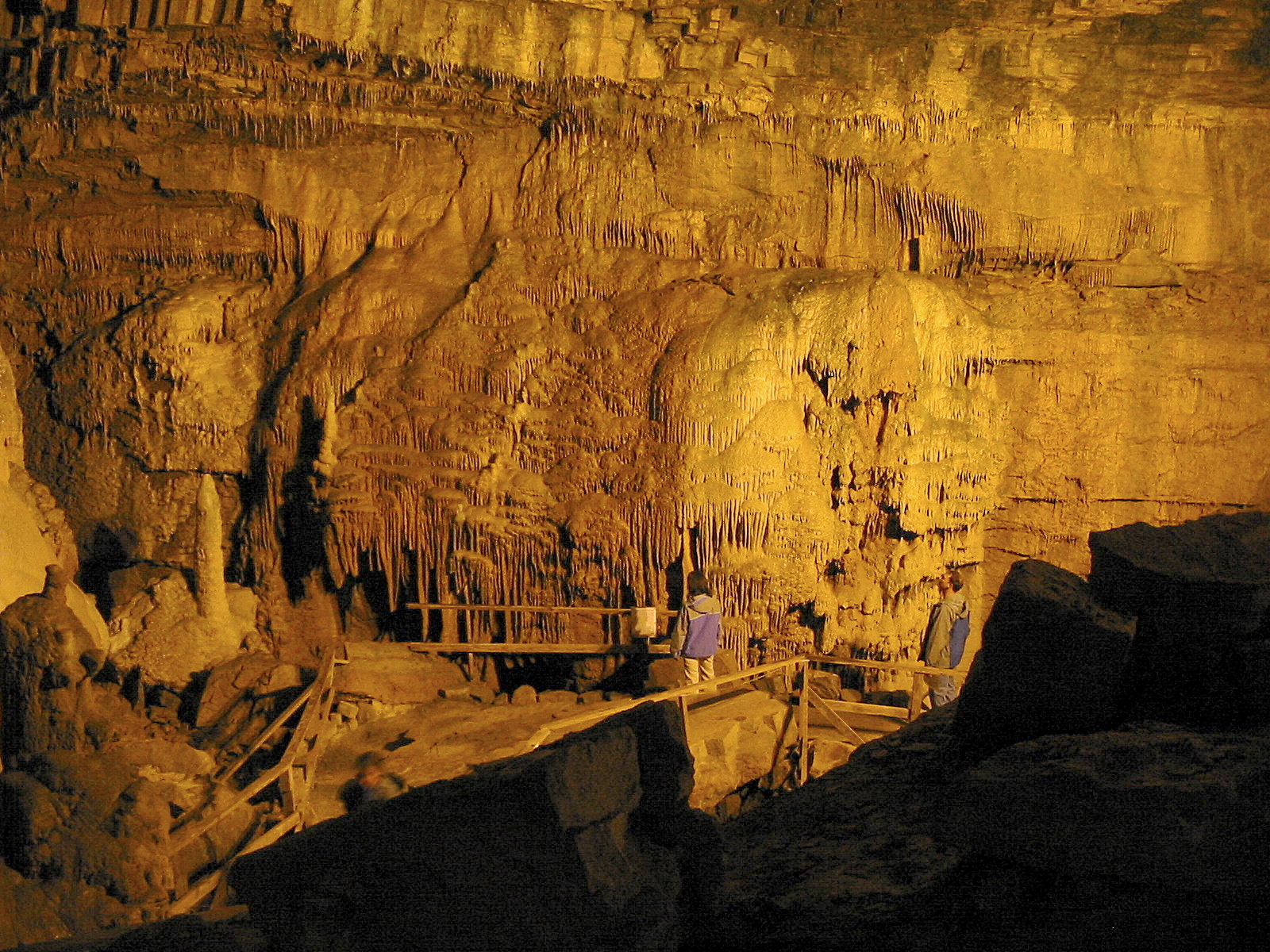 Two people observing the majestic rock formations at Lost World Caverns, one of the best attractions in West Virginia