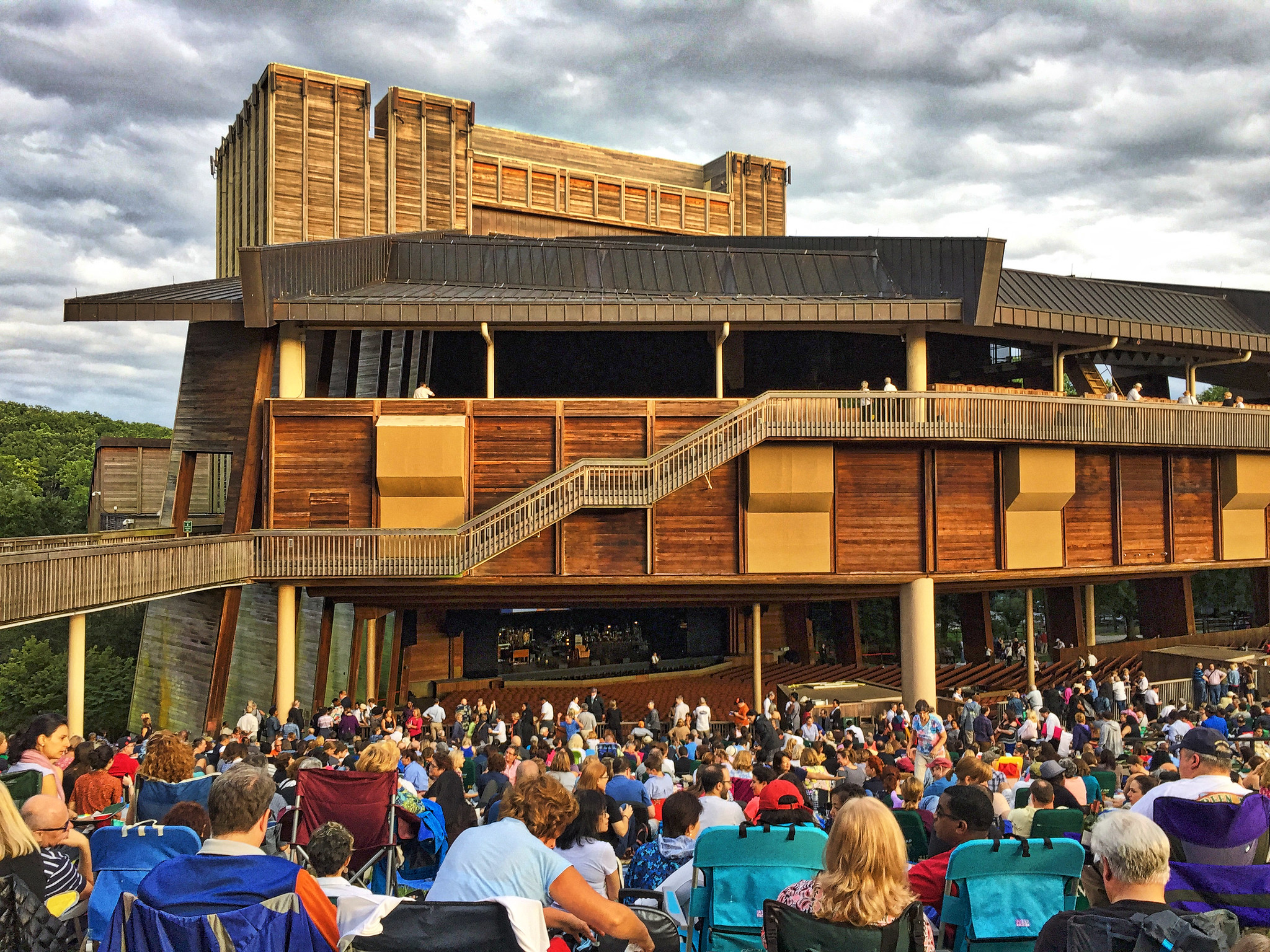 A large crowd sitting in front of the gigantic Wolf Trap National Park for the Performing Arts, one of the things to do in Virginia