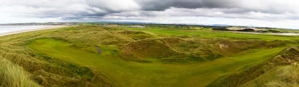 Panoramic photo of the vast green golf course at Enniscrone Golf Club, pictured on a cloudy day for a piece on the best golf courses in Ireland