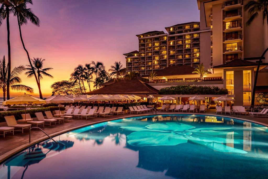 Image of the pool and hotel rooms overlooking it for a piece on the best resorts in Hawaii