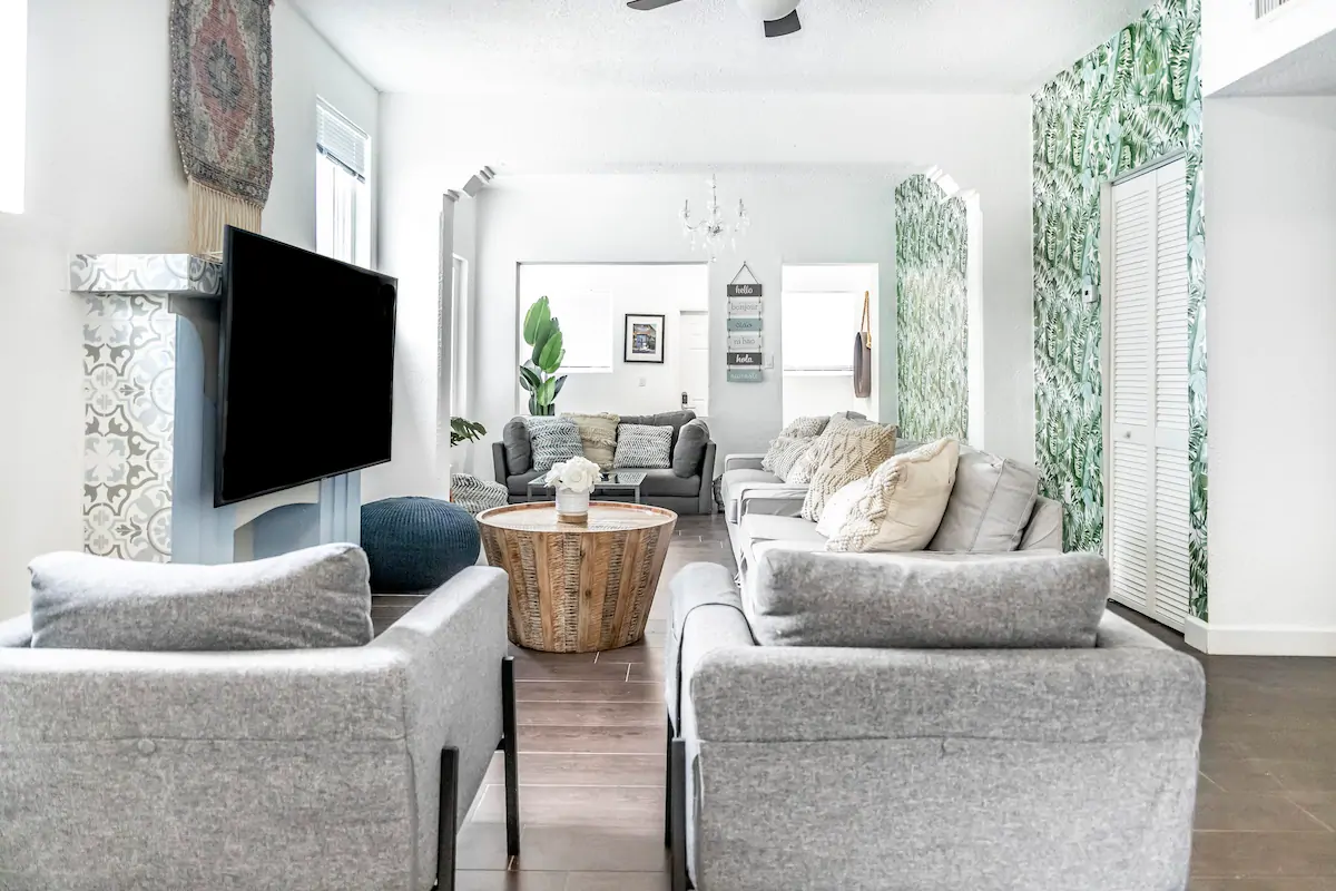 A large television in front of a grey sofa set at Miami Private Villa, a piece on the best bachelorette Airbnbs