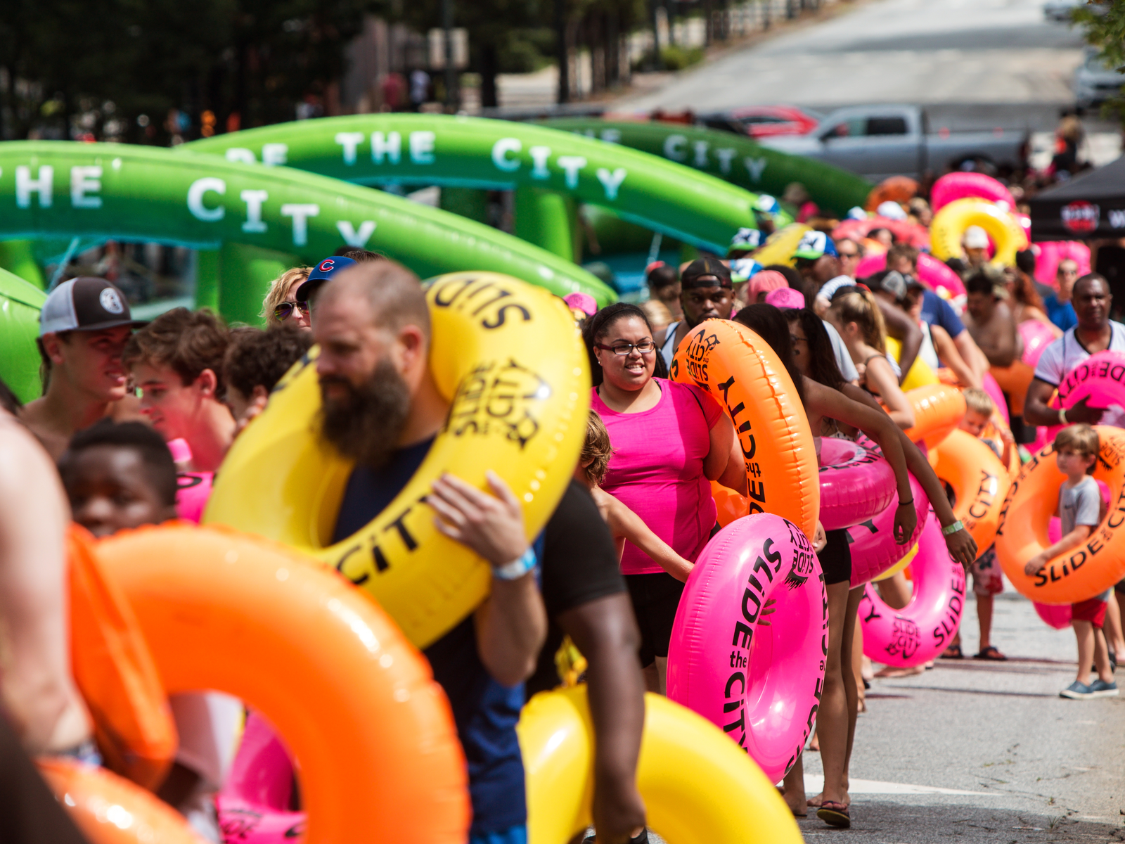 People in their swim shirts carrying swim rings as they get in line at Slide the City in Downtown Atlanta, one of the best water parks in the USA