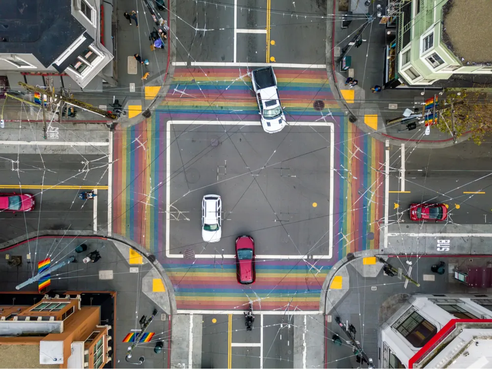 Rainbow crosswalk in Castro, one of the best places to visit in San Francisco, and few cars crossing an intersection