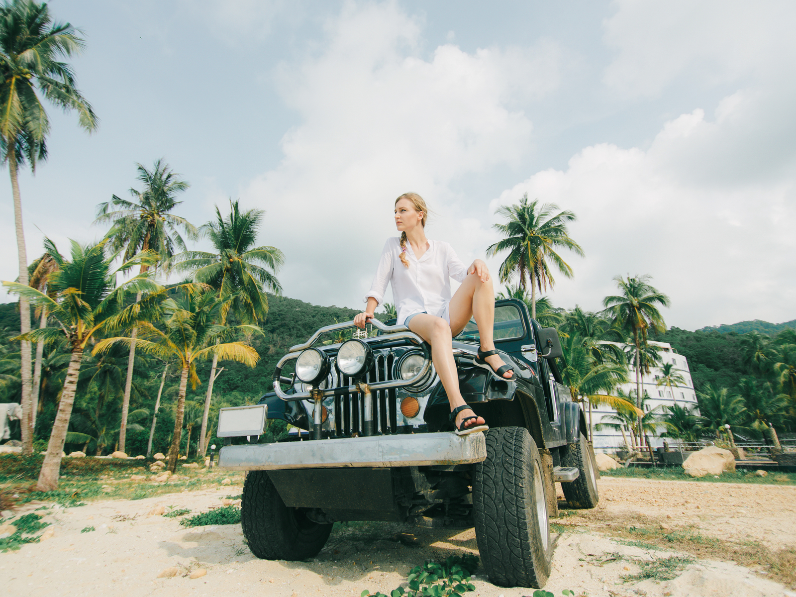 Girl sitting on the hood of a jeep for a piece on the best things to do in Saint Lucia