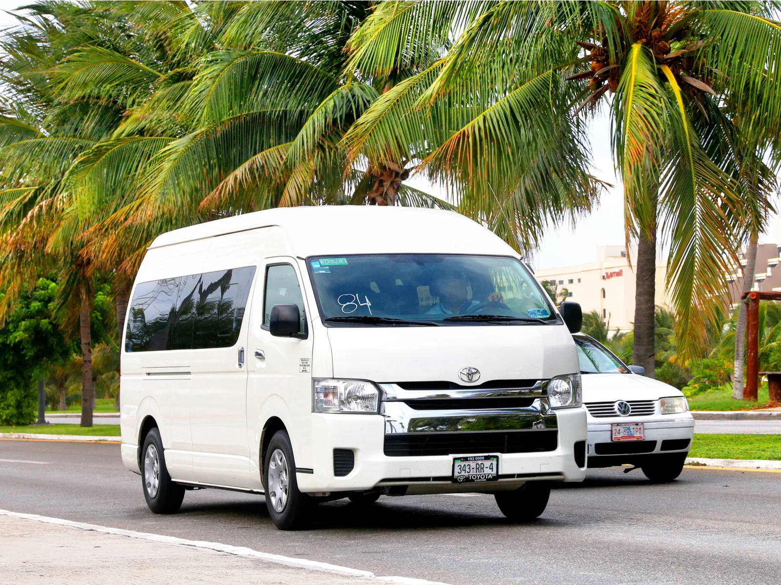 Photo of a taxi van under a palm tree for a roundup of the best hotels in Tulum