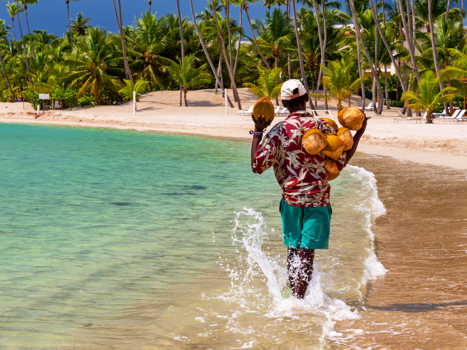 Guy selling coconuts walking in the beach for a piece on the best resorts in the Dominican Republic