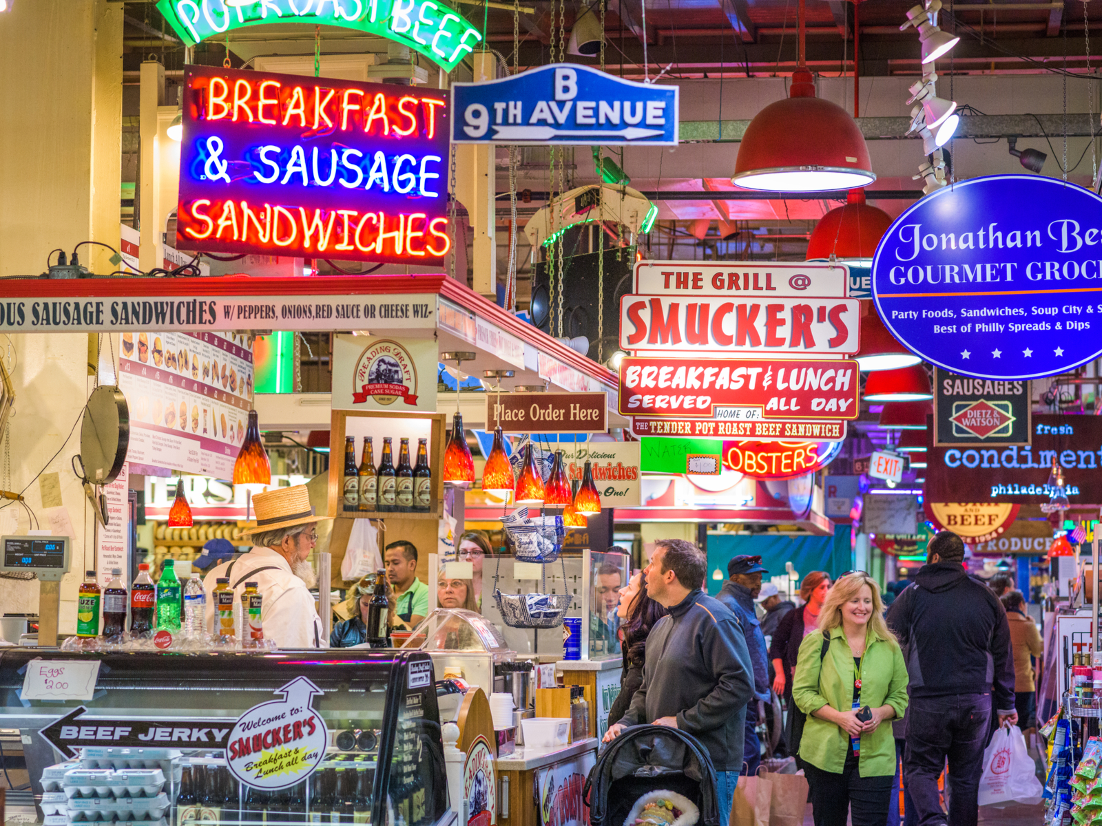 Vendors and customers in the busy Reading Terminal Market, one of the best things to do in Pennsylvania, with many signages of stores and products