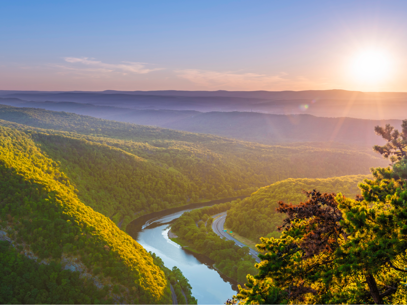 Aerial view of the lush forest and winding river at Delaware Water Gap Recreation Area during a fresh sunrise, hiking this trail is one of the best things to do in New Jersey