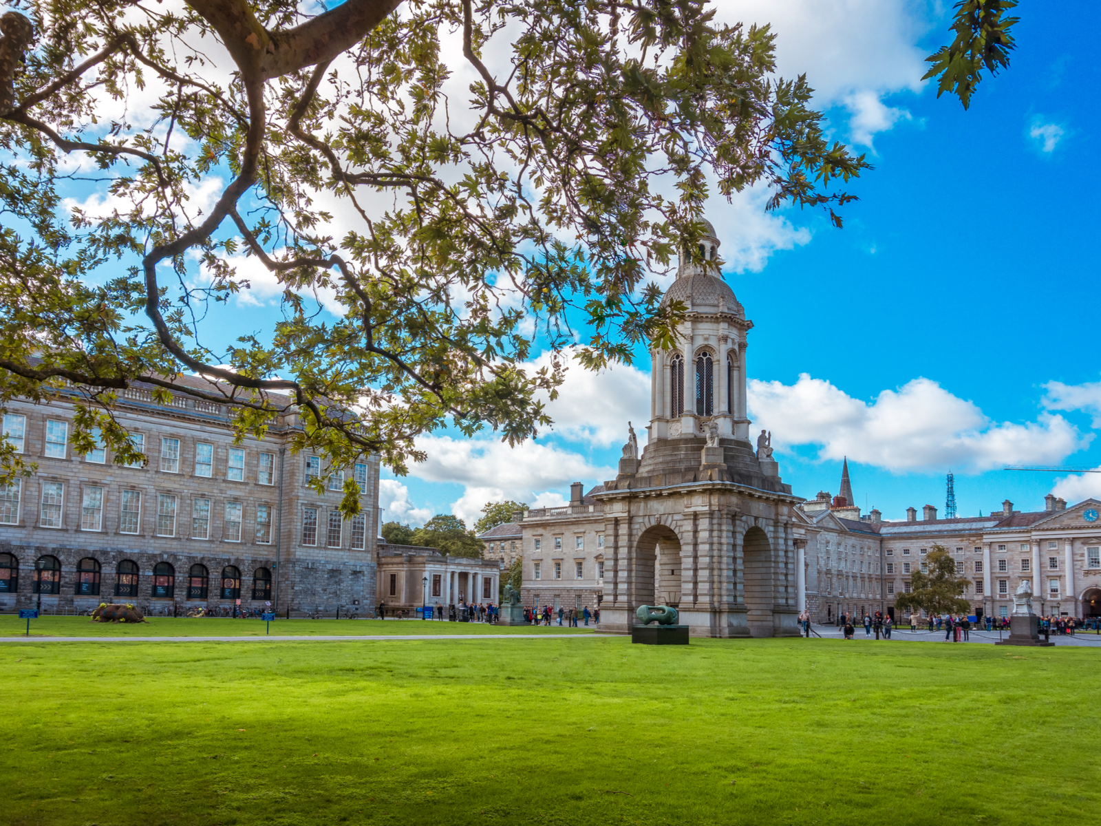 Students and parents gathered in front of the Campanile inside Trinity College Campus in Dublin, with green trimmed lawn on its rear, considered as one of the best universities in Ireland