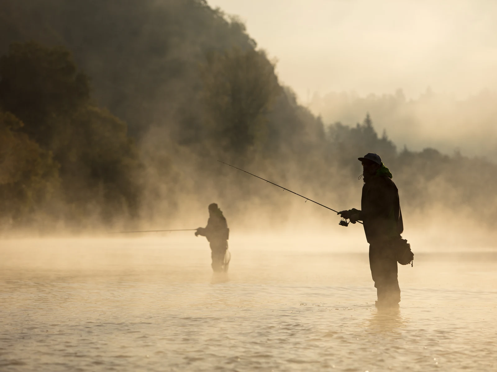 One of the best things to do in Costa Rica, two men photographed fly fishing on a foggy morning