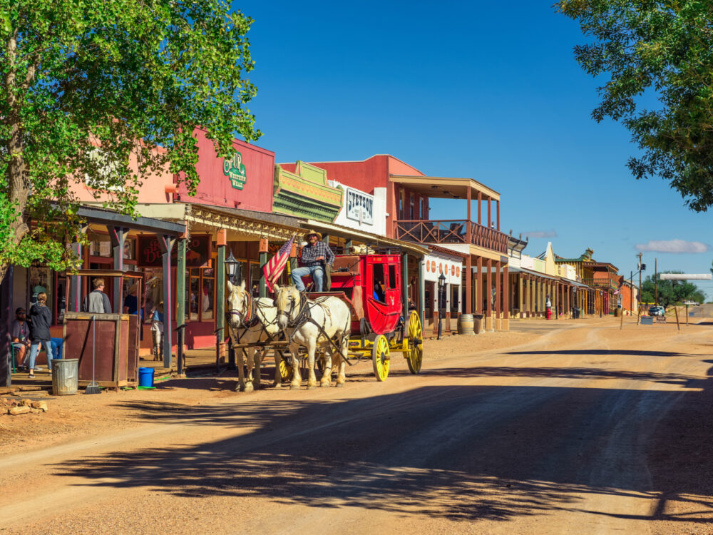 Horses pulling a carriage down the dirt road in Tombstone, one of the best places to visit in Arizona