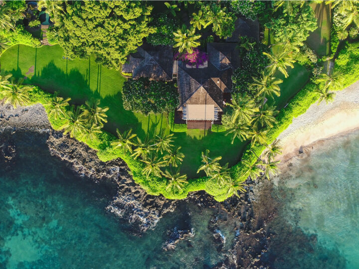 Aerial image of one of the best Airbnbs in Hawaii pictured from above with the yard running up to the coastline