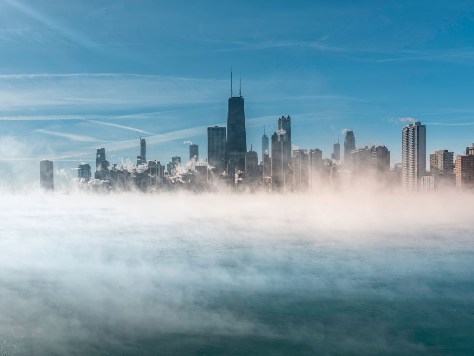 Worst time to visit Chicago symbolized by a photo of Lake Michigan with lots of fog and snow