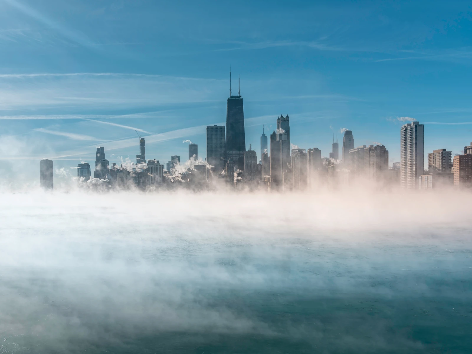 Worst time to visit Chicago symbolized by a photo of Lake Michigan with lots of fog and snow