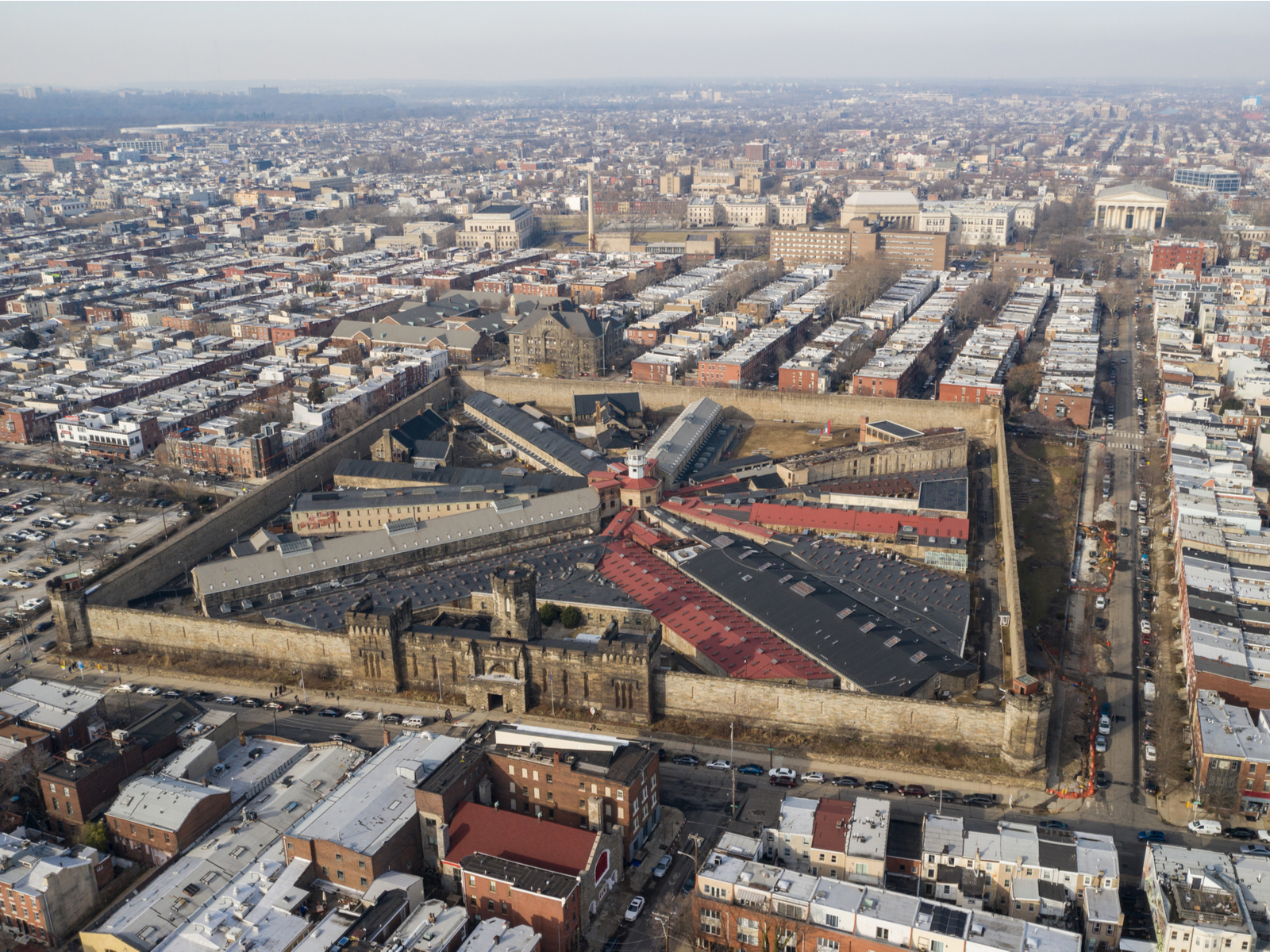Aerial shot on one of best things to do in Pennsylvania, the vast Eastern State Penitentiary with its tall borders and downtown Philadelphia