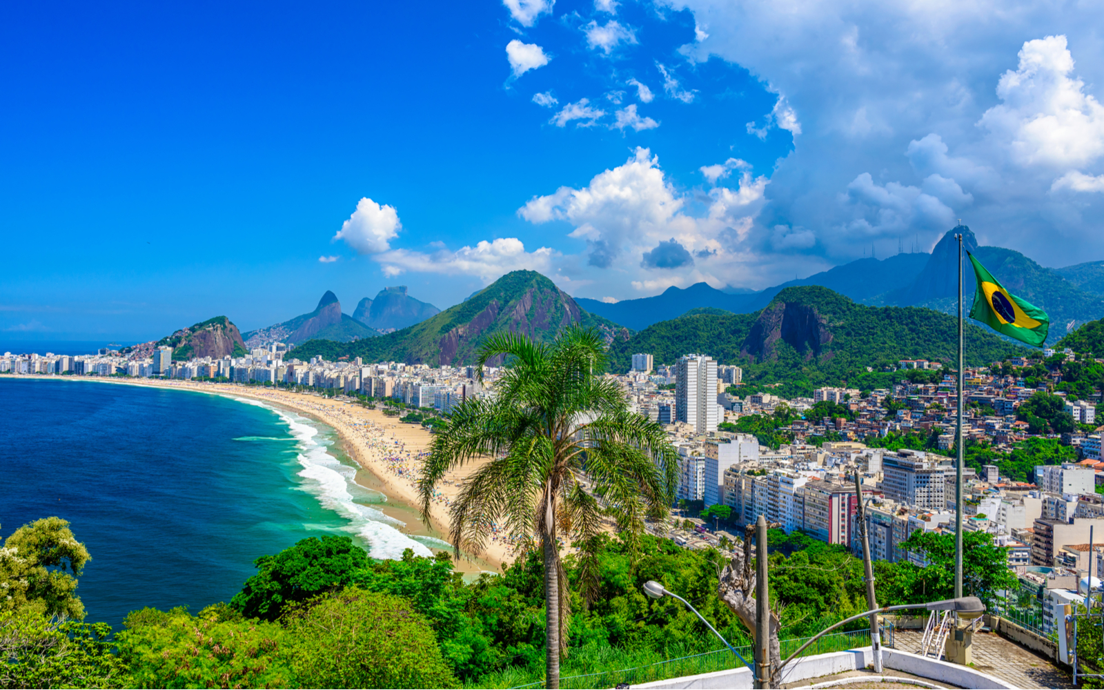 Copacabana beach in Rio de Janiero pictured during the best time to visit Brazil with clear teal water and blue sky