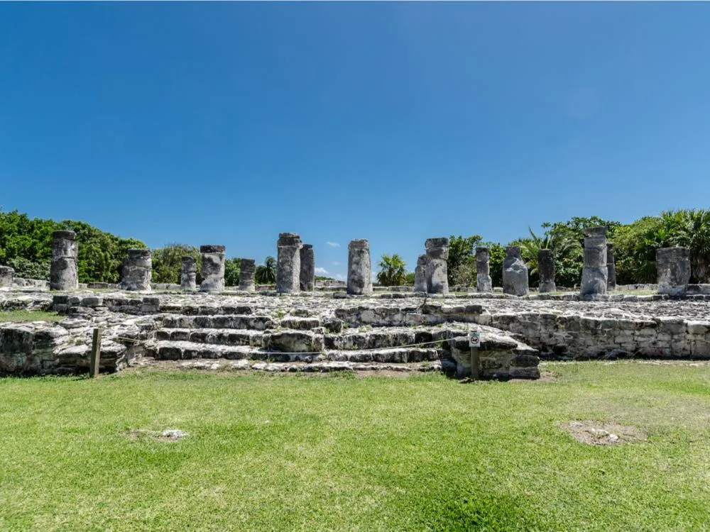 Mysterious elongated old stone blocks at El Rey Archaeological Zone photographs on a bright clear day as a piece on the best things to do in Cancun