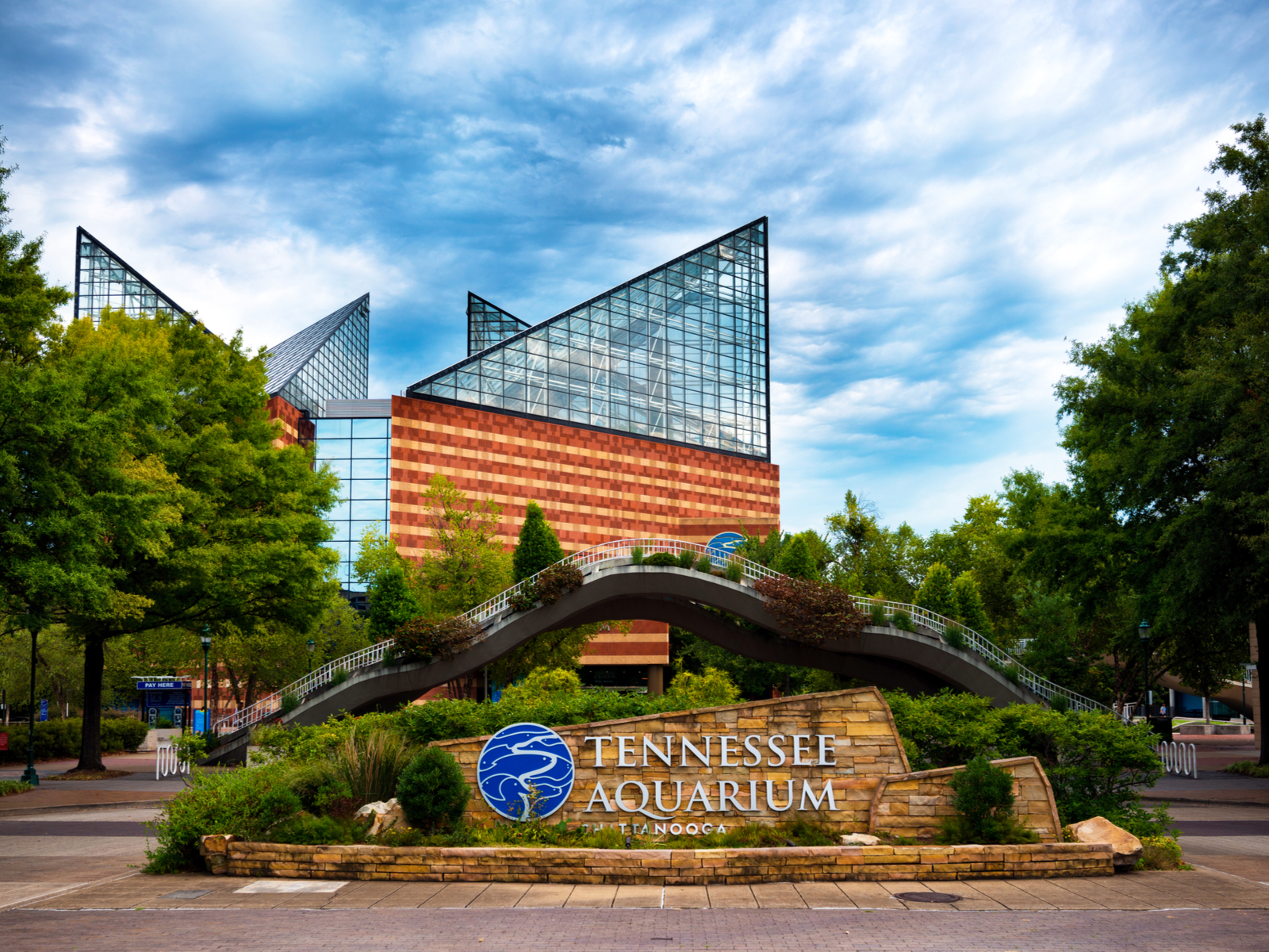 The Tennessee Aquarium is one of the best things to do in Tennessee which houses thousands of animal species, pictured with its signage and facilities during a cloudy day