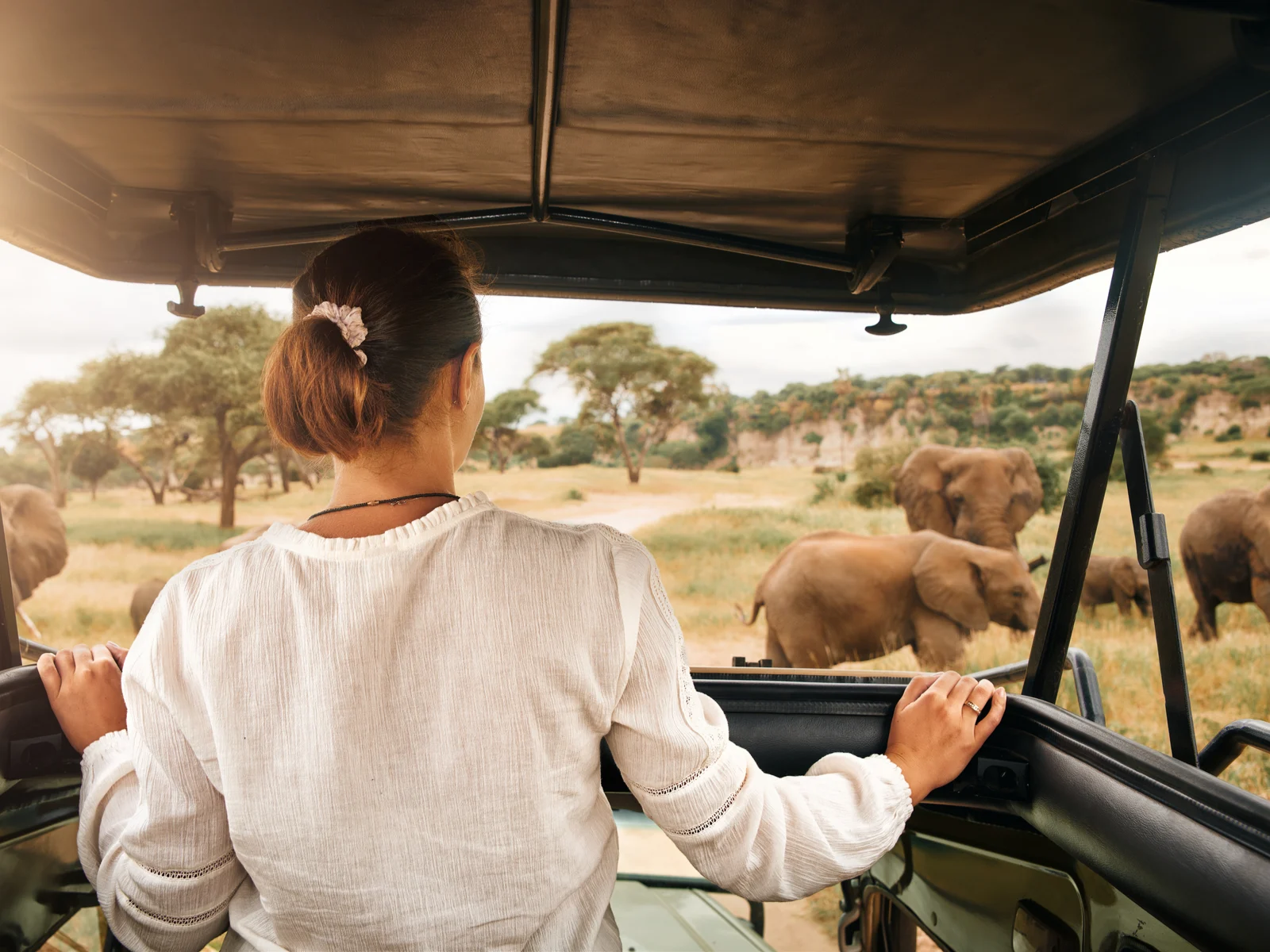 Woman on one of the best safaris in Africa in Kenya sitting on the top of a vehicle
