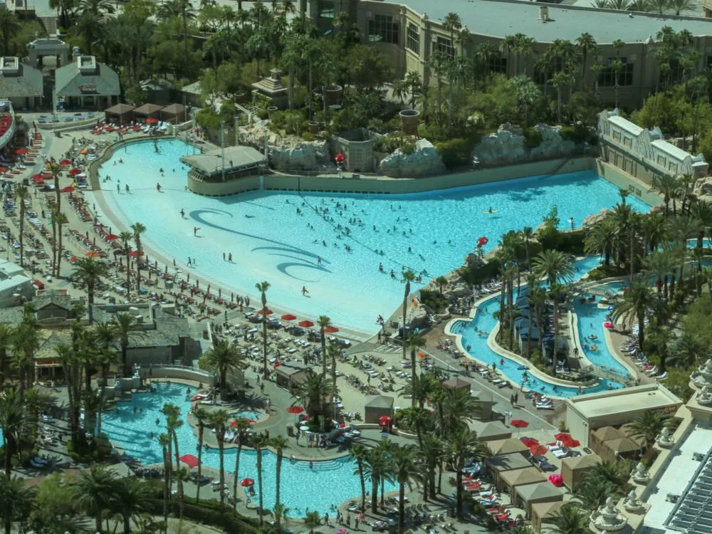 Aerial view of Mandalay Bay Resort in Las Vegas, one of the best water parks in the USA, with people swimming on the clear pool and laying down on sunloungers 