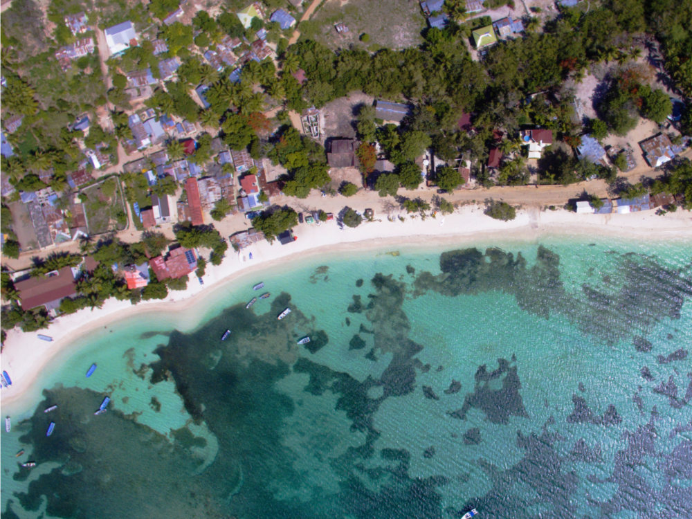 Overhead view on one of the best beaches in the Dominican Republic, Punta Rucia with a number of residential houses offshore and few boats sailing its crystal clear waters