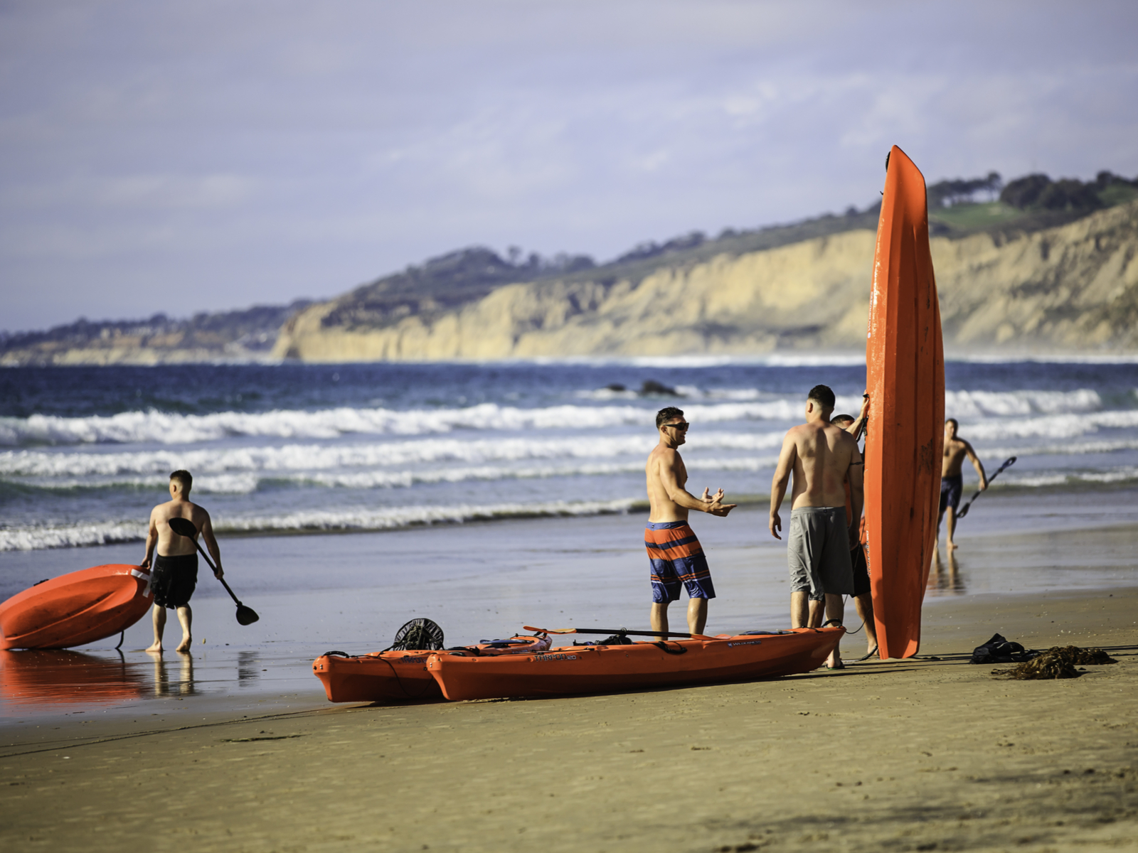 People holding kayaks in La Jolla, one of the best things to do in San Diego