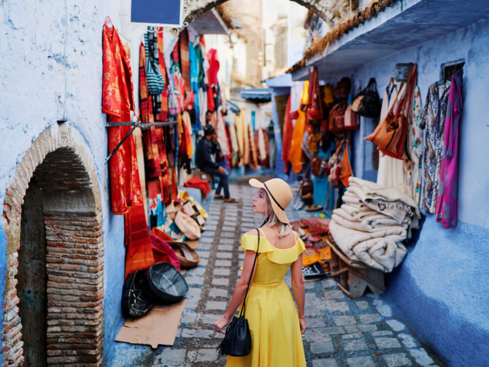 Colorful clothes in a market as seen by a woman in a yellow dress for a piece titled Is Morocco Safe