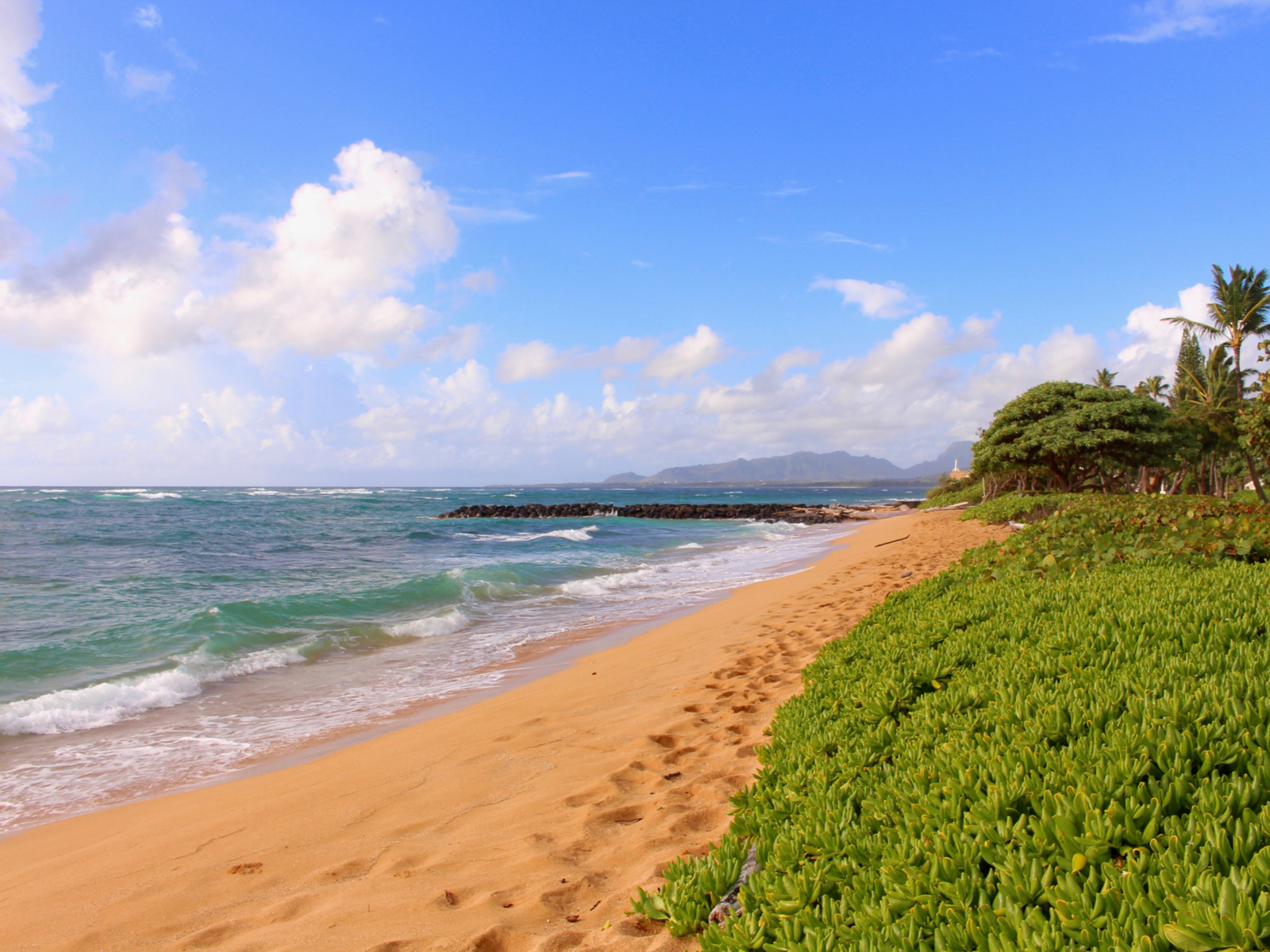 Sunny day on a beach in one of the best places to stay in Hawaii, Kapaa