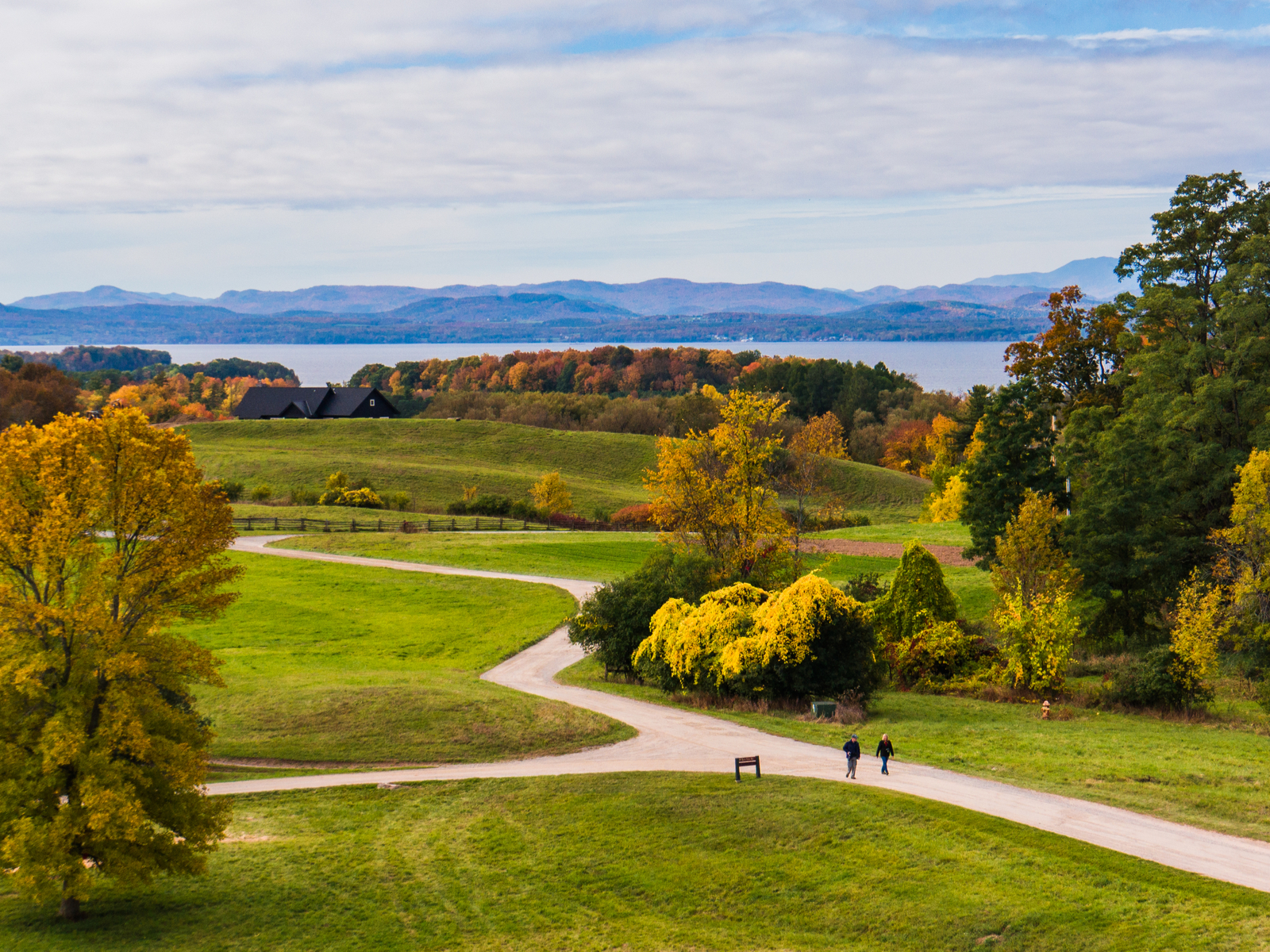 Two folks walking along a path in a park near Lake Champlain, one of the best places to visit in Vermont